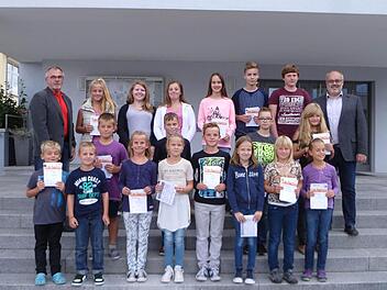 Mit Erfolg legten 25 Kinder und Jugendliche in Oerlenbach das Sportabzeichen ab. Ihre Leistungen würdigte Bürgermeister Franz Kuhn (hinten rechts), der vor allem Organisator und Prüfer Gerhard Fischer (hinten links) lobte.  Foto: Stefan Geiger