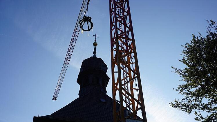 Über der Kirche am Kreuzberg schwebt die Krone des Richtfestes. Foto:  Marion Eckert