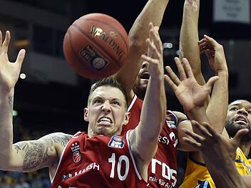 Entschlossen gehen die Bamberger zum Rebound. Daniel Theis (l.) schnappt sich den Ball, der Berliner Reggie Redding (r.) geht leer aus. Fotos: dpa, Katharina Förtsch (4)