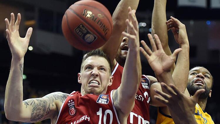 Entschlossen gehen die Bamberger zum Rebound. Daniel Theis (l.) schnappt sich den Ball, der Berliner Reggie Redding (r.) geht leer aus. Fotos: dpa, Katharina Förtsch (4)