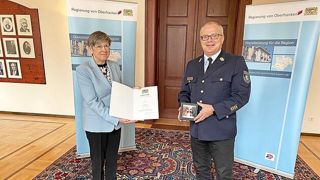 Regierungspr&auml;sidentin Heidrun Piwernetz &uuml;berreicht Kreisbrandrat Timm Vogler das Feuerwehrsteckkreuz.