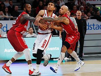 Die Würzburger Marshawn Powell (l.) und Maurice Stuckey (r.) greifen dem Bamberger Aufbauspieler Maodo Lo in den Arm. Fotos: Daniel Löb