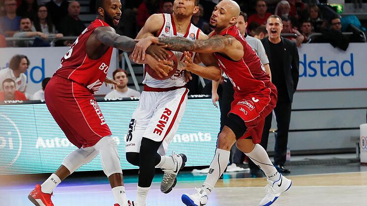 Die Würzburger Marshawn Powell (l.) und Maurice Stuckey (r.) greifen dem Bamberger Aufbauspieler Maodo Lo in den Arm. Fotos: Daniel Löb