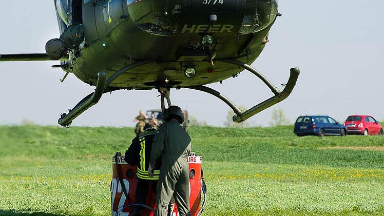 Helfer am Boden klinken den Löschbehälter ein. Foto: Tobias Köpplinger