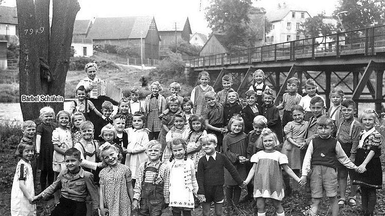 Der Unterricht im Freien erfreute 1949 die Mainleuser Erstklässler - darunter Bärbel Schülein, geborene Kohl (mit Pfeil), die  das Foto   zur Verfügung stellte. Im Hintergrund die damalige eiserne Mainbrücke, die jetzt saniert worden ist und am Freitag wieder für den Verkehr freigegeben wird. Foto: privat