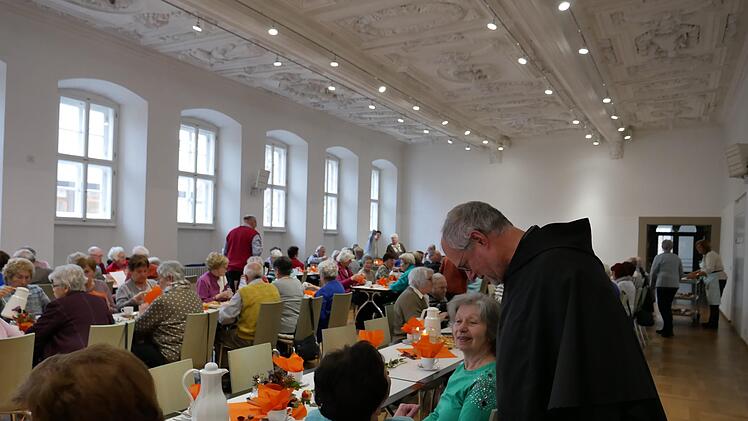 Stadtpfarrer P. Markus Reis begrüßte die Besucher des Seniorentags in der alten Aula am Stenayer Platz und nutzte die Veranstaltung für Gespräche.  Foto: Heike Beudert