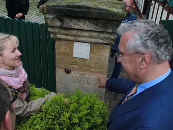 Andrea Helmuth zeigt Innenminister Joachim Herrmann am Portal ihres Hofs die historischen Hochwassermarken. Ganz so hoch war das Wasser am 31. Mai zum Glück nicht gestiegen, aber die Flutwelle kam erschreckend schnell - und im Hof stand das Wasser immerhin knietief. Fotos: Matthias Einwag
