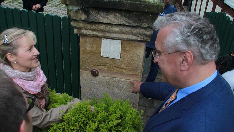 Andrea Helmuth zeigt Innenminister Joachim Herrmann am Portal ihres Hofs die historischen Hochwassermarken. Ganz so hoch war das Wasser am 31. Mai zum Glück nicht gestiegen, aber die Flutwelle kam erschreckend schnell - und im Hof stand das Wasser immerhin knietief. Fotos: Matthias Einwag