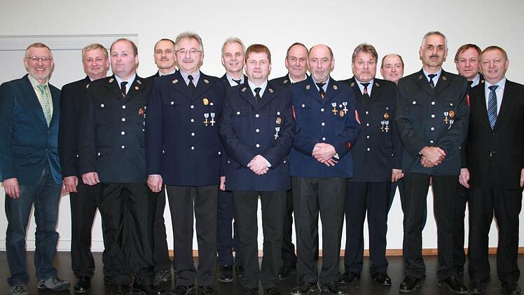 Bürgermeister Waldemar Bug (links) und Landrat Thomas Bold (rechts) gratulieren den aktiven Feuerwehrleuten.