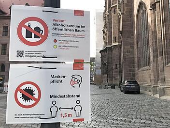 In Nürnberg zeigt die Corona-Ampel seit Anfang vergangener Woche Rot. Hinweisschilder weisen auf die Maskenpflicht, den Mindestabstand, aber auch den eingeschränkten Alkoholkonsum hin.  Foto: Michael Busch