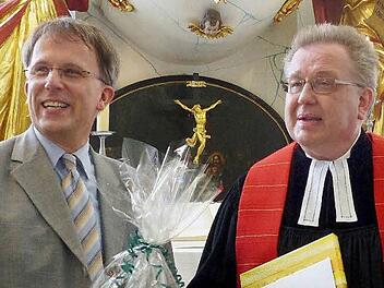 Thomas Grünke nimmt von Pfarrer Peter Ahrens die Glückwünsche zum 30-jährigen Jubiläum als Kirchenmusiker entgegen. Foto: Dieter Hübner
