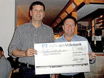 Obmann Michael Wolf (rechts) übergibt Marktgemeinderat Bernd Daum den riesigen Scheck. Foto: nn