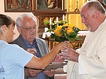 Die Ehrennadel des Bistums Würzburg übergab Pater Rudolf Theiler (rechts) an Walter Schmidt (Mitte) in Würdigung seiner jahrzehntelangen Verdienste für die katholische Kirche in Ebern. Blumen gab es dazu von Pfarramtssekretärin Veronika Müller (links). Foto: Helmut Will