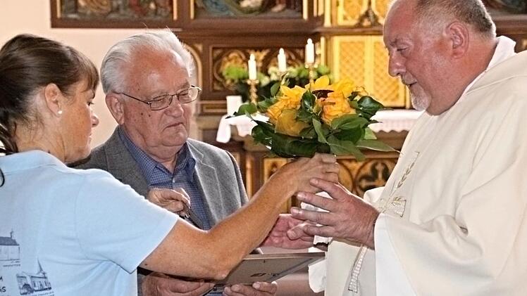 Die Ehrennadel des Bistums Würzburg übergab Pater Rudolf Theiler (rechts) an Walter Schmidt (Mitte) in Würdigung seiner jahrzehntelangen Verdienste für die katholische Kirche in Ebern. Blumen gab es dazu von Pfarramtssekretärin Veronika Müller (links). Foto: Helmut Will