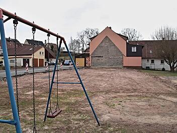 Die Spielgeräte für den neuen Spielplatz in Pfaffendorf, der auf dieser Freifläche, wo das ehemalige Schulhaus stand, angelegt werden soll, stehen in den "Startlöchern", wie Bürgermeister Wolfram Thein am Montag sagte. Die alte Schaukel (links) steht schon mal. Helmut Will