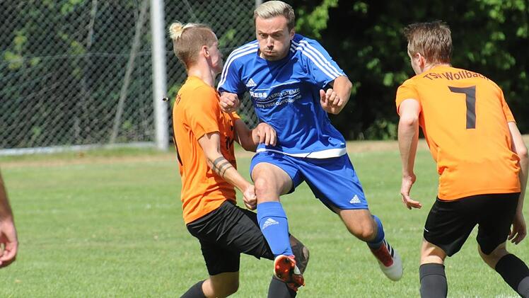 Arnshausens Tobias Vogel schlüpft  zwischen Wollbachs Tim Landau (links) und Konstantin Metz hindurch.ssp