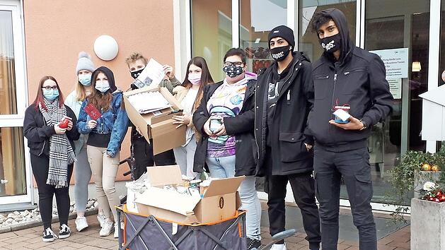 Die Neuntkl&auml;ssler "fahren" ihre Geschenken beim Seniorenzentrum vor.  Fotos: Andrea Sp&ouml;rlein