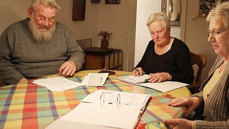 Gerhard und Herta Mencl sowie Irmgard Lippold (von links) blättern in den Unterlagen der Nebenkostenabrechnung. Fotos: Friedwald Schedel