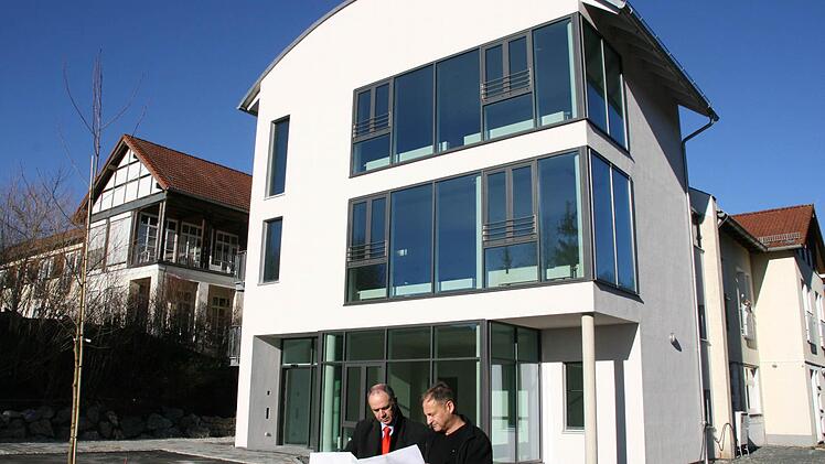 Der imposante Anbau mit dem neuen Hauptzugang zum Seniorenheim, einem weiteren Aufzug und zwei Aufenthaltsräumen darüber. Heimleiter Thomas Hammer (rechts) erläutert Bürgermeister Franz Uome schon einmal die Pläne für die Neugestaltung der Gartenanlagen, die ebenfalls noch ansteht. Foto: Matthias Beetz