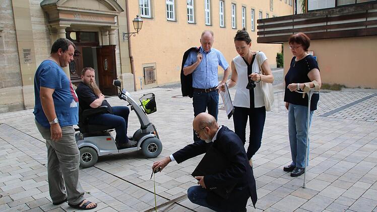 Etwas zu tief sind die Absätze am Stenayer Platz, stellt Helmut Beck fest. Doch dieser Mängel wird durch die Breite der Rinnen ausgeglichen. Ganz unproblematisch sind diese dennoch nicht, vor allem für Sehbehinderte. Zusammen mit Beck überprüften Burkhard Schodorf, Thomas Seuberling, Helmut Blank, Antje Rink und Regina Seit , wie gut die Barrierefreiheit in der Altstadt ist. Foto: Heike Beudert