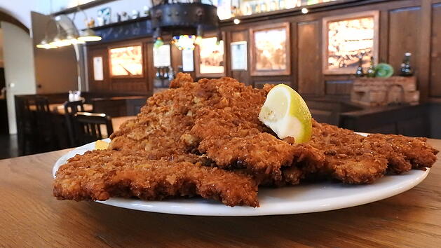 Das Schnitzel im Gr&uuml;ner Brauhaus wird mit hausgemachten Brezenbr&ouml;seln paniert. Dazu wird Gr&uuml;ner Naturtr&uuml;b ausgeschenkt.