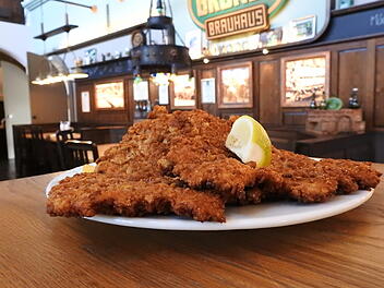 Das Schnitzel im Gr&uuml;ner Brauhaus wird mit hausgemachten Brezenbr&ouml;seln paniert. Dazu wird Gr&uuml;ner Naturtr&uuml;b ausgeschenkt.