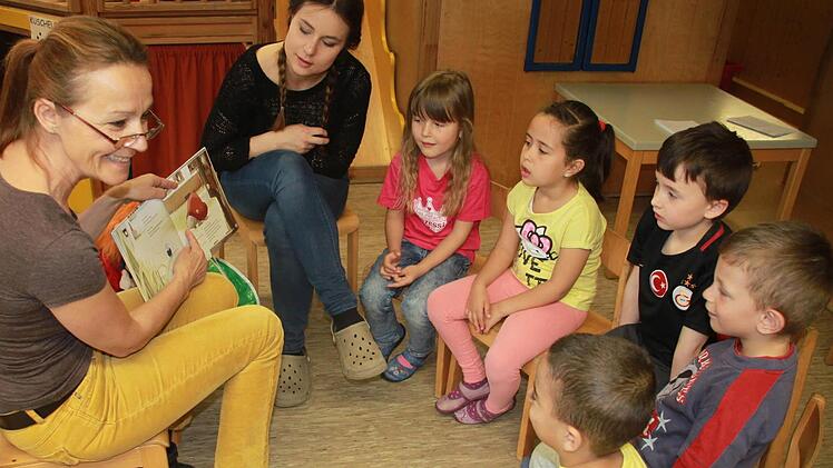 Sprachförderkraft Renate Benson (links), die den Kindern hier die Schnecke Martha vorstellt, und Berufspraktikantin Ronja Sünkel betreuen die Sprachfördergruppe an der Kita "Grünschnabel" in Redwitz.  Foto: Andreas Schmitt