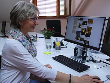 Elfriede Klauer an ihrem neuen Arbeitsplatz im Haus Sankt Bruno in Haßfurt. In der Bilddatenbank sind aktuell schon wieder Weihnachtsbilder gefragt. Doch ein Pfarrbrief braucht laut Klauer auch drei Monate Vorlauf. Foto: Lisa Kieslinger
