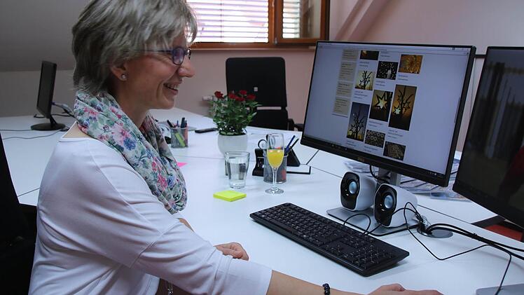 Elfriede Klauer an ihrem neuen Arbeitsplatz im Haus Sankt Bruno in Haßfurt. In der Bilddatenbank sind aktuell schon wieder Weihnachtsbilder gefragt. Doch ein Pfarrbrief braucht laut Klauer auch drei Monate Vorlauf. Foto: Lisa Kieslinger