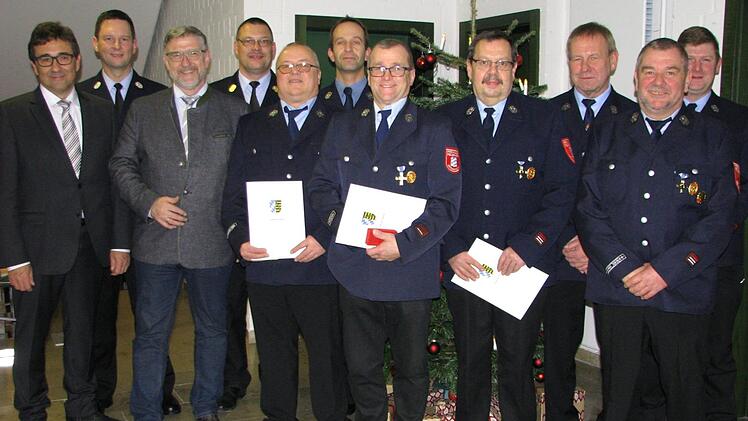 Die mit silbernen und goldenen Ehrenzeichen bedachten Wehrleute mit B&uuml;rgermeister Rolf Rosenbauer (links) und Landrat Michael Busch (Dritter von links).                Foto: Norbert Karbach