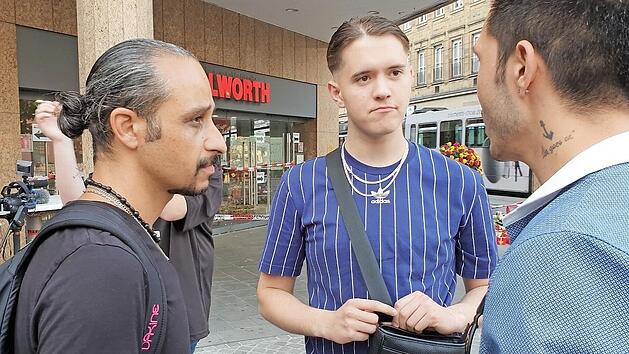 Die Augenzeugen Chia Rabiei (l), Kurde mit iranischer Staatsbürgerschaft, und Dietrich Winter unterhalten sich vor dem Kaufhaus in der Innenstadt, in dem ein Mann Menschen mit einem Messer attackiert hatte.