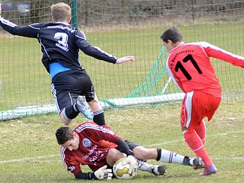 Hammerbachs Keeper Markus Schaufler rettet in dieser Situation vor einem einschussbereiten Dechsendorfer (rotes Trikot). Foto: herzopress