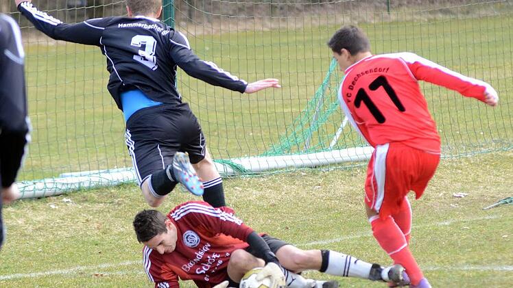 Hammerbachs Keeper Markus Schaufler rettet in dieser Situation vor einem einschussbereiten Dechsendorfer (rotes Trikot). Foto: herzopress