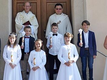 Die Kommunionkinder aus Kothen und Motten. Vordere Reihe (von links): Hanna Dehler, Mathilda Sturm, Amelie Herbert und Emily Möring. Mittlere Reihe (von links): Julian Dätig, Nick Porzelt, Maximilian Kömpel und Moritz Sturm. Im Hintergrund Pfarrer Hans Thurn (links) und Diakon Kim Sell.  Foto: Petra Heurich
