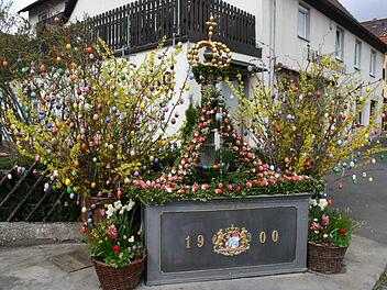 Der Brunnen am Dorfplatz stammt aus dem Jahr 1900 und wird zu Ostern festlich geschmückt. Fotos: Reinhard Löwisch