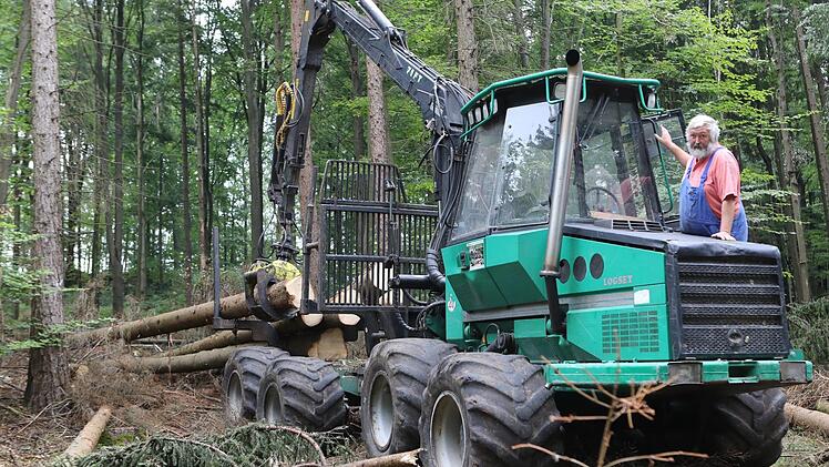 Günther Lehnes holt mit seinem Rückezug gefällte Bäume  aus dem Wald und legt sie für den Weitertransport an einem Weg ab.