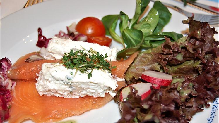 Die Vorspeise aus Räucherlachs und Frischkäse mit Tomate, Radieschen und Salaten