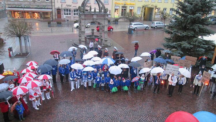 Unter Regenschirmen und mit aufweichenden Protestplakaten stellte das Narrenvolk Bürgermeister Armin Warmuth zur Rede.  Fotos: W. Ehling