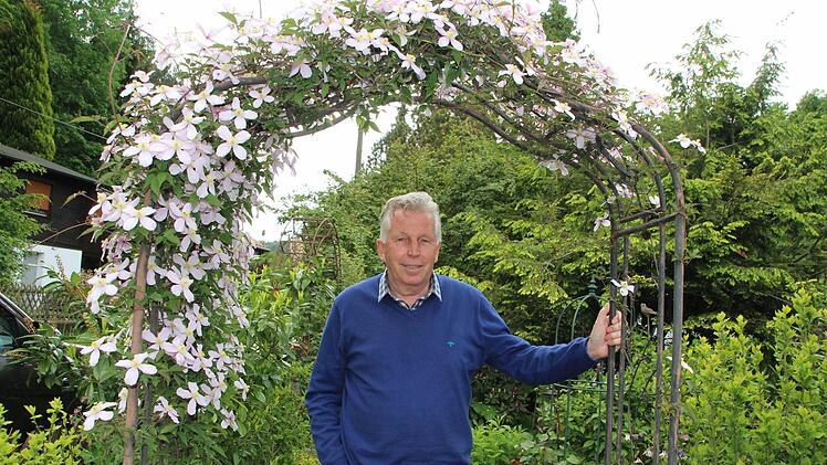 Roland Betz unter dem Clematis-Bogen seines Gartens in der Fränkischen Schweiz. Foto: Roepert