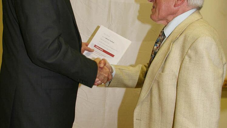 Volker Kirschenlohr, der Vorsitzende der Sängergruppe Steinach, schüttelt Willi Guldner die Hände. Willi Guldner wurde zum Ehrendirigenten der Chorgemeinschaft Wartenfels-Schwand ernannt.