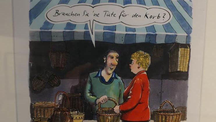 Überspitzt, aber mit einem gehörigen Körnchen Wahrheit, wird hier der Verpackungswahn auf die Schippe genommen. Nachdenken ist ausdrücklich erwünscht. Foto: Marion Eckert/Karikatur: Freimut Woessner