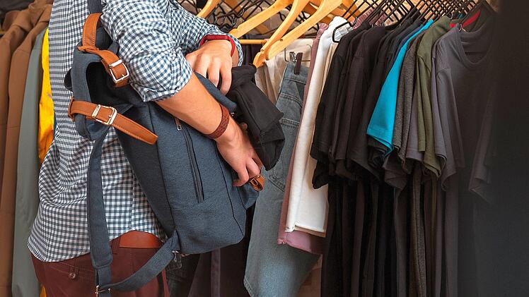 Mann klaut mit Rucksack in Bekleidungsgesch&auml;ft