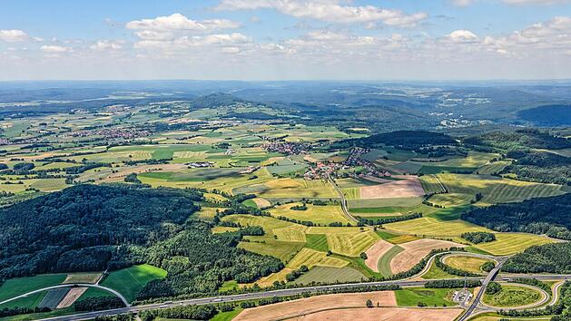 In Schondras Marktgemeinderat wurden &Uuml;berlegungen der Gemeinde Oberleichtersbach diskutiert, die die Kreisstra&szlig;e durch Breitenbach (oberer linker Bildrand) und Mitgenfeld (davor) vom Landkreis &uuml;bernehmen will. Im Vordergrund die Autobahn A7.  Archivfoto: Klaus Leidorf/Bund Naturschutz