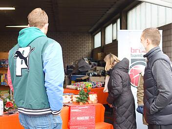 Auf dem Gelände der Tafel standen viele Geschenke für Bedürftige bereit. Links Chris Sengfelder von den Brose Baskets, der auch Kartoffelsuppe an die ehrenamtlichen Helfer der Tafel ausgab.