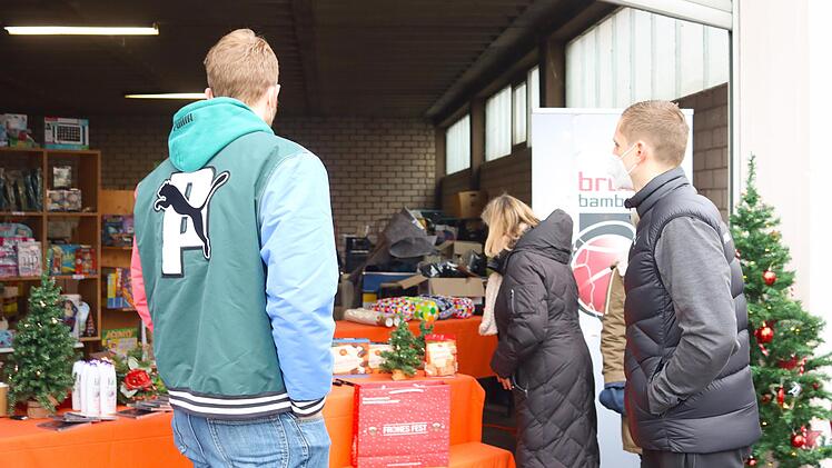 Auf dem Gelände der Tafel standen viele Geschenke für Bedürftige bereit. Links Chris Sengfelder von den Brose Baskets, der auch Kartoffelsuppe an die ehrenamtlichen Helfer der Tafel ausgab.