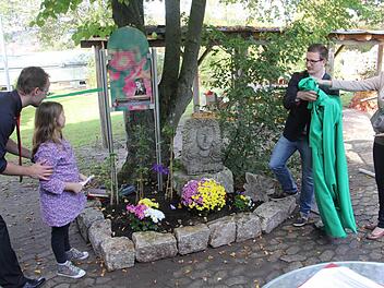 Julia, von der Klasse 5a (zweite von links) durfte, nachdem sie ein Gedicht von Friedrich Rückert vorgetragen hatte, mit älteren Mitschülern (rechts) eine tafel in der Schulgartenanlage am Friedrich-Rückert-Gymnasium in Ebern symbolisch enthüllen. Links im Bild Studienrat Martin Wolf, der das Projekt betreut.  Foto: Helmut Will