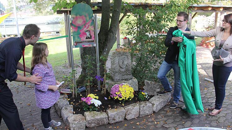 Julia, von der Klasse 5a (zweite von links) durfte, nachdem sie ein Gedicht von Friedrich Rückert vorgetragen hatte, mit älteren Mitschülern (rechts) eine tafel in der Schulgartenanlage am Friedrich-Rückert-Gymnasium in Ebern symbolisch enthüllen. Links im Bild Studienrat Martin Wolf, der das Projekt betreut.  Foto: Helmut Will