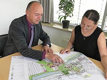 Weisendorfs Bürgermeister Heinrich Süß und die zuständige Mitarbeiterin im Rathaus Lisa Schaub besprechen die weiteren Änderungen in der Marktgemeinde. Auffällig ist der "grüne Kern" Weisendorfs.  Foto: Michael Busch