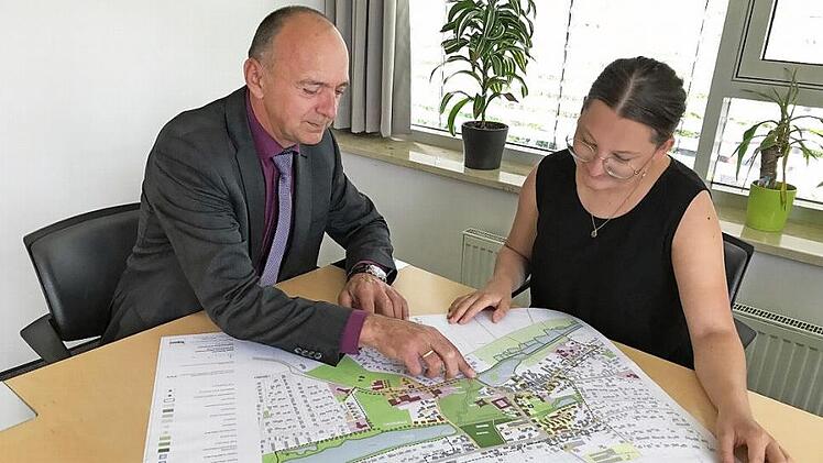 Weisendorfs Bürgermeister Heinrich Süß und die zuständige Mitarbeiterin im Rathaus Lisa Schaub besprechen die weiteren Änderungen in der Marktgemeinde. Auffällig ist der "grüne Kern" Weisendorfs.  Foto: Michael Busch