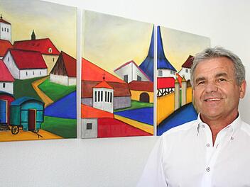 Bürgermeister Ludwig Nagel vor den Bildern im Rathaus, die Hemhofener Motive zeigen. Foto: Evi Seeger